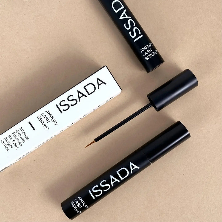 ISSADA Amplify Eyelash Serum with applicator on a beige background