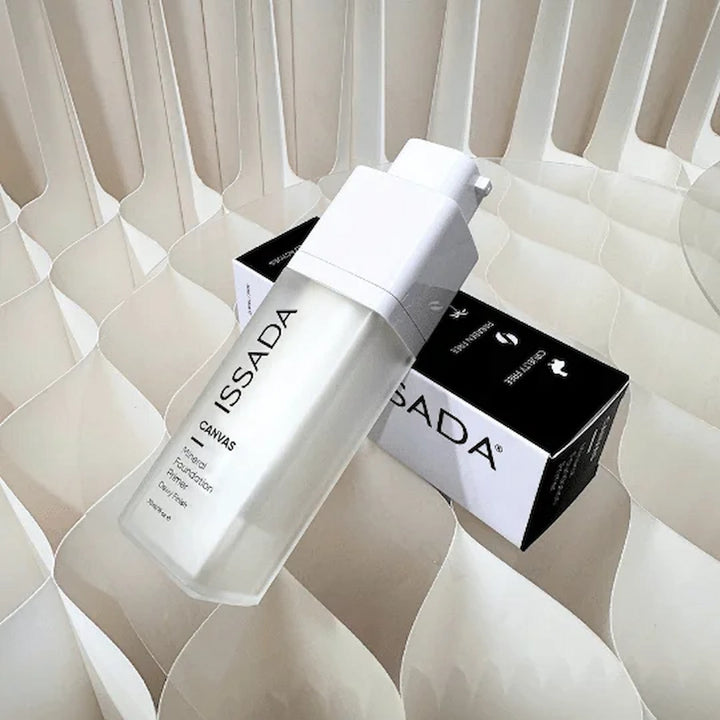 ISSADA skincare bottle and box on a textured beige surface