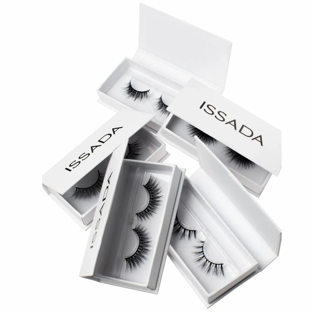 Multiple pairs of ISSADA Lashed Up eyelashes in white boxes, designed for dramatic volume and reusable wear