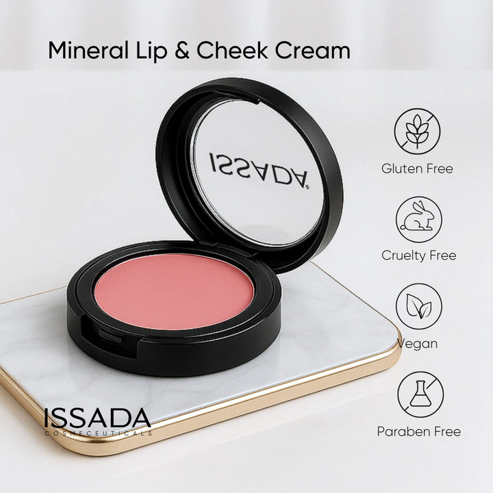 Issada Mineral Lip & Cheek Cream in a pink shade displayed on a marble tray, with icons highlighting its clean beauty attributes — Gluten Free, Cruelty Free, Vegan, and Paraben Free.