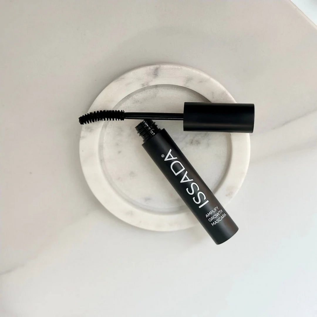 ISSADA Amplify Growth Mascara with curved wand on marble dish