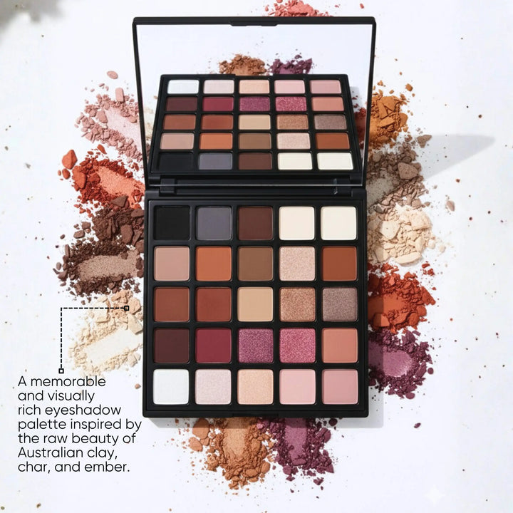 ISSADA Clay & Ember Mineral Eyeshadow palette open with 25 earthy matte and shimmer shades surrounded by crushed pigment powders