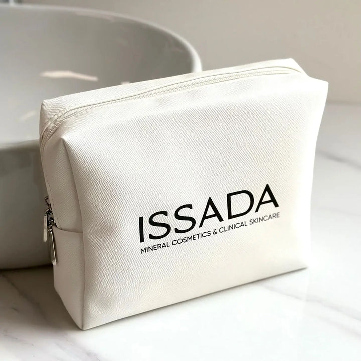 White ISSADA Cosmetics Bag displayed on a marble surface, perfect for storing makeup and skincare essentials.