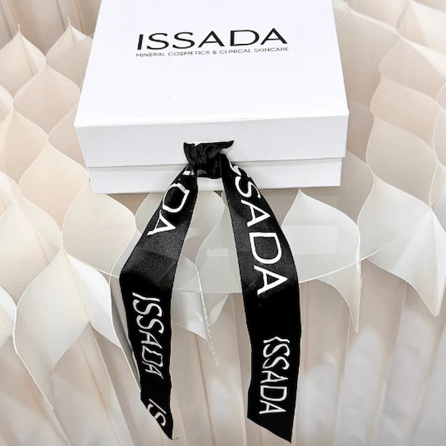 Elegant Issada white gift box tied with a black branded ribbon, perfect for luxury skincare and cosmetics gifting.