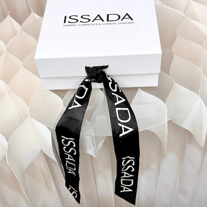 Elegant Issada white gift box tied with a black branded ribbon, perfect for luxury skincare and cosmetics gifting.