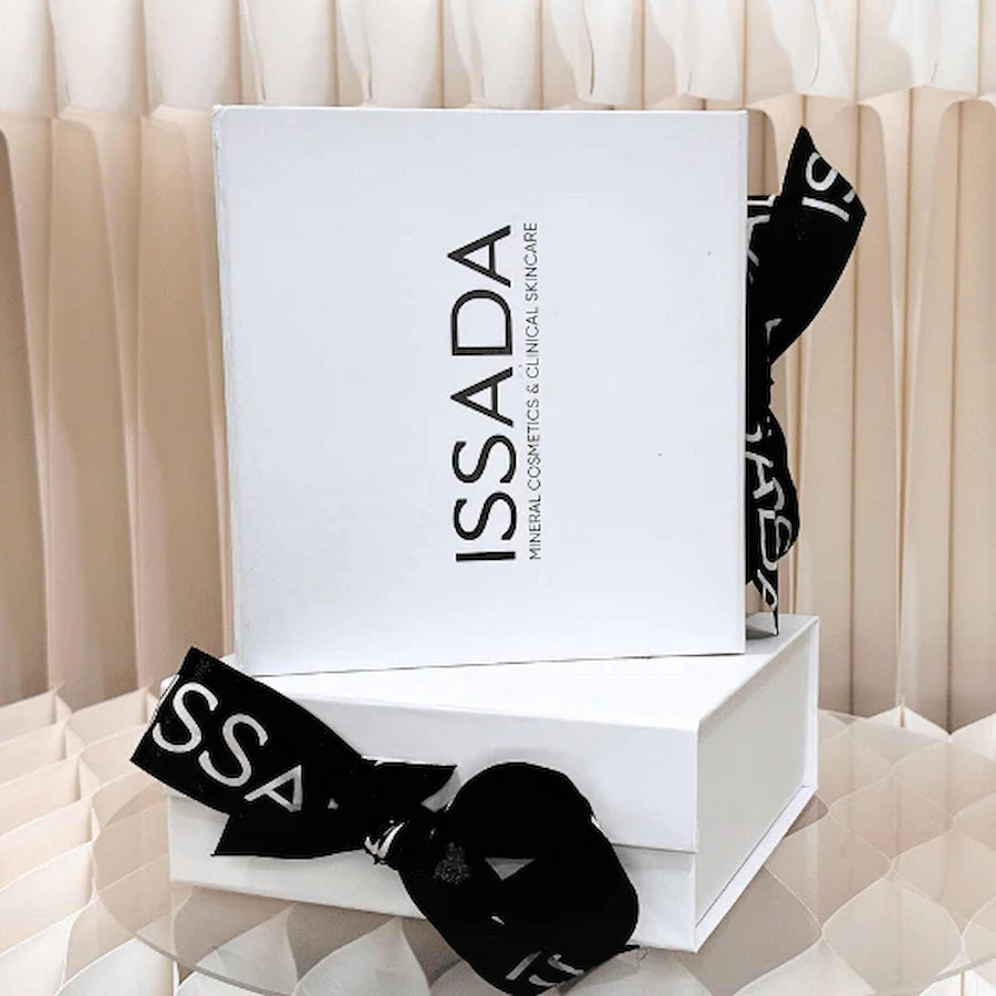 Elegant Issada white gift box tied with a black logo ribbon, perfect for luxury skincare and cosmetics gifting.