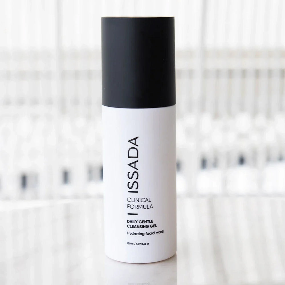 ISSADA Daily Gentle Cleansing Gel bottle on a marble counter with blurred background