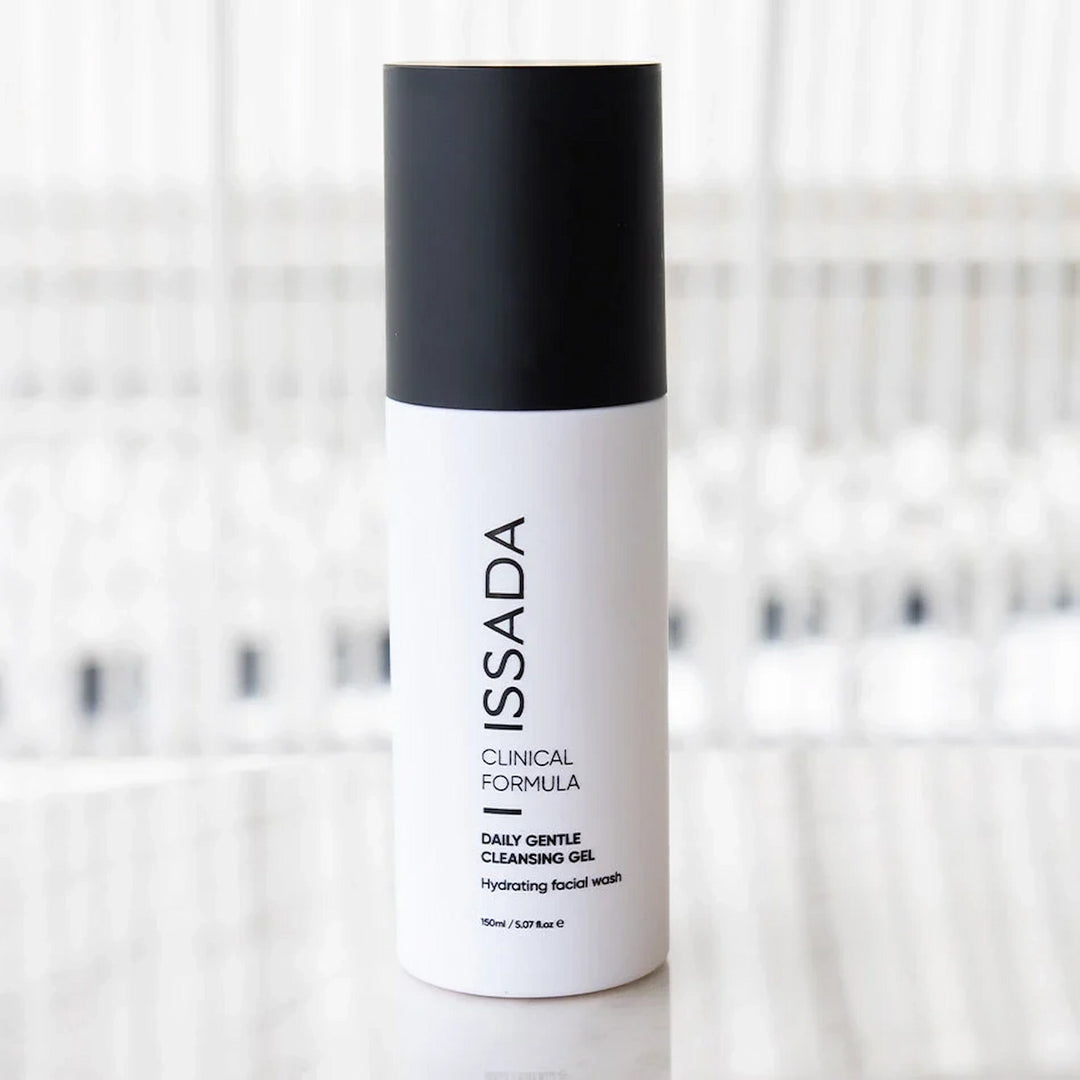 ISSADA Daily Gentle Cleansing Gel bottle on a marble counter with blurred background