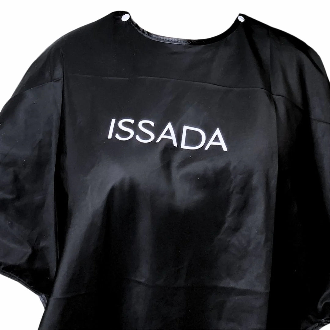 Black Issada makeup artist cape with logo, designed to protect clothing during professional makeup application.
