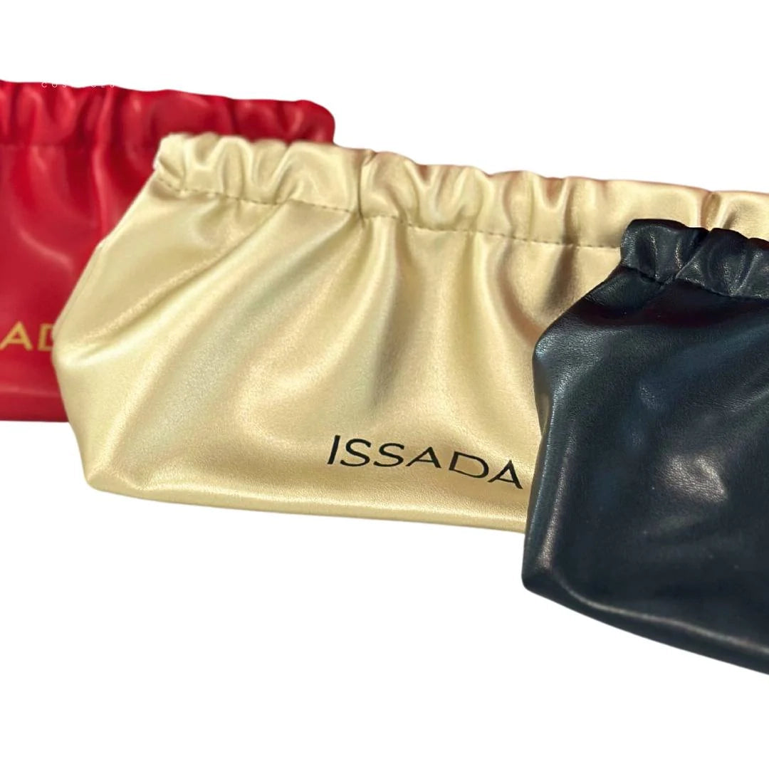 Elegant Issada makeup clutch bags in red, gold, and black with a soft satin-like finish and drawstring closure.