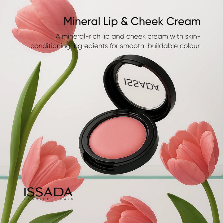Issada Mineral Lip & Cheek Cream in a pink shade displayed among soft pink tulips, emphasizing its mineral-rich, skin-conditioning formula for smooth, buildable color.