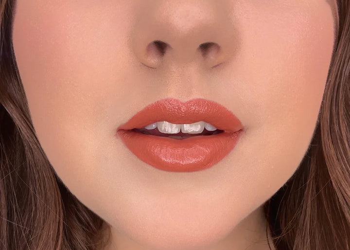 Close-up of a woman's lips with ISSADA Mineral Lip Crayon in Fulfilled, a warm terracotta lip shade with a creamy, soft-matte finish.