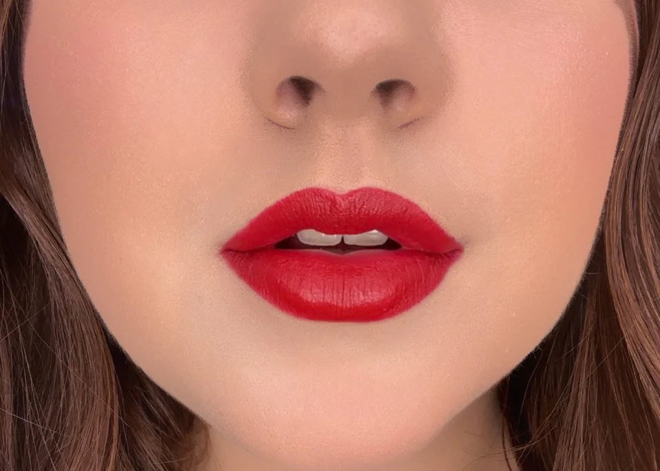 Close-up of a woman's lips wearing Issada Mineral Lip Crayon in Gratitude, a bold classic red lip shade with a creamy, soft-matte finish.