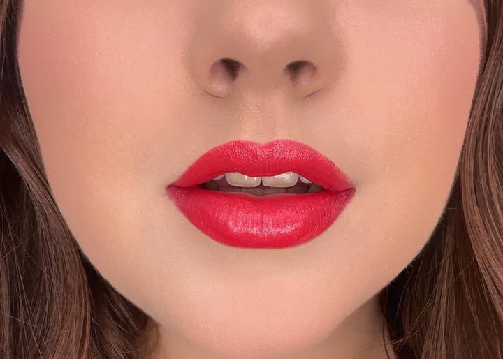 Close-up of model wearing ISSADA Mineral Lip Crayon in Happiness shade, a vibrant red-pink with a creamy, soft-matte finish.