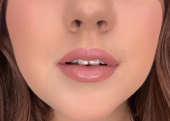 Close-up of a woman's lips with ISSADA Mineral Lip Crayons in relaxed shade, a soft dusty rose with a creamy matte finish.