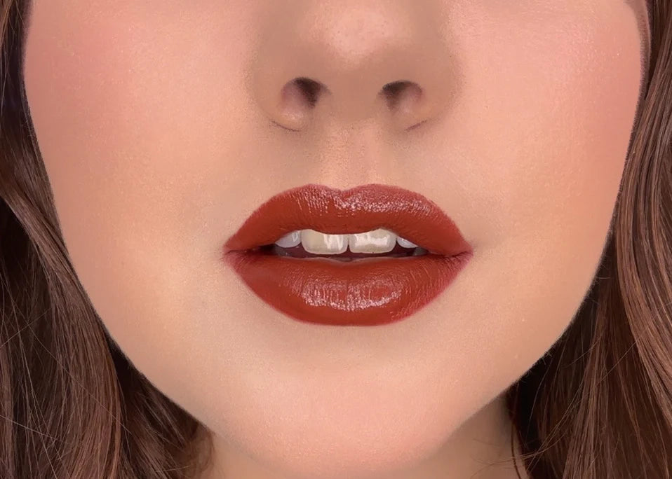 Close-up of model wearing ISSADA Mineral Lip Crayons in Strong shade, a bold deep brown-red shade with a creamy matte finish.