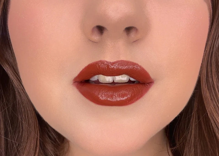 Close-up of model wearing ISSADA Mineral Lip Crayons in Strong shade, a bold deep brown-red shade with a creamy matte finish.