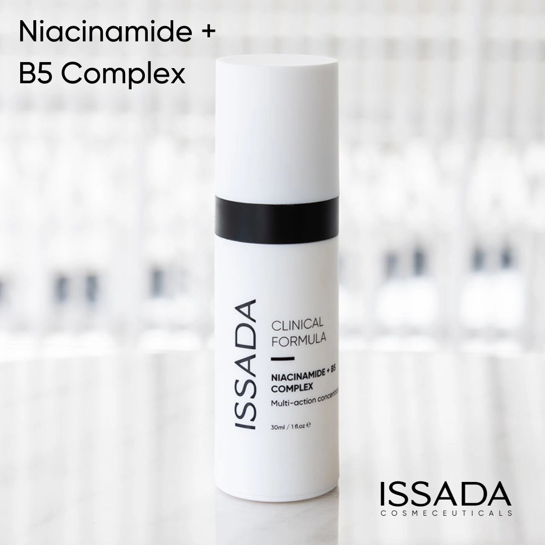 Issada Niacinamide + B5 Complex Clinical Formula serum bottle displayed on a reflective surface with a soft blurred background, showcasing the minimalist skincare packaging design.