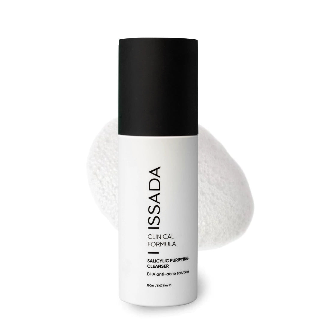 Issada Salicylic Purifying Cleanser bottle with foamy white cleanser swatch in the background, showcasing the BHA anti-acne solution.