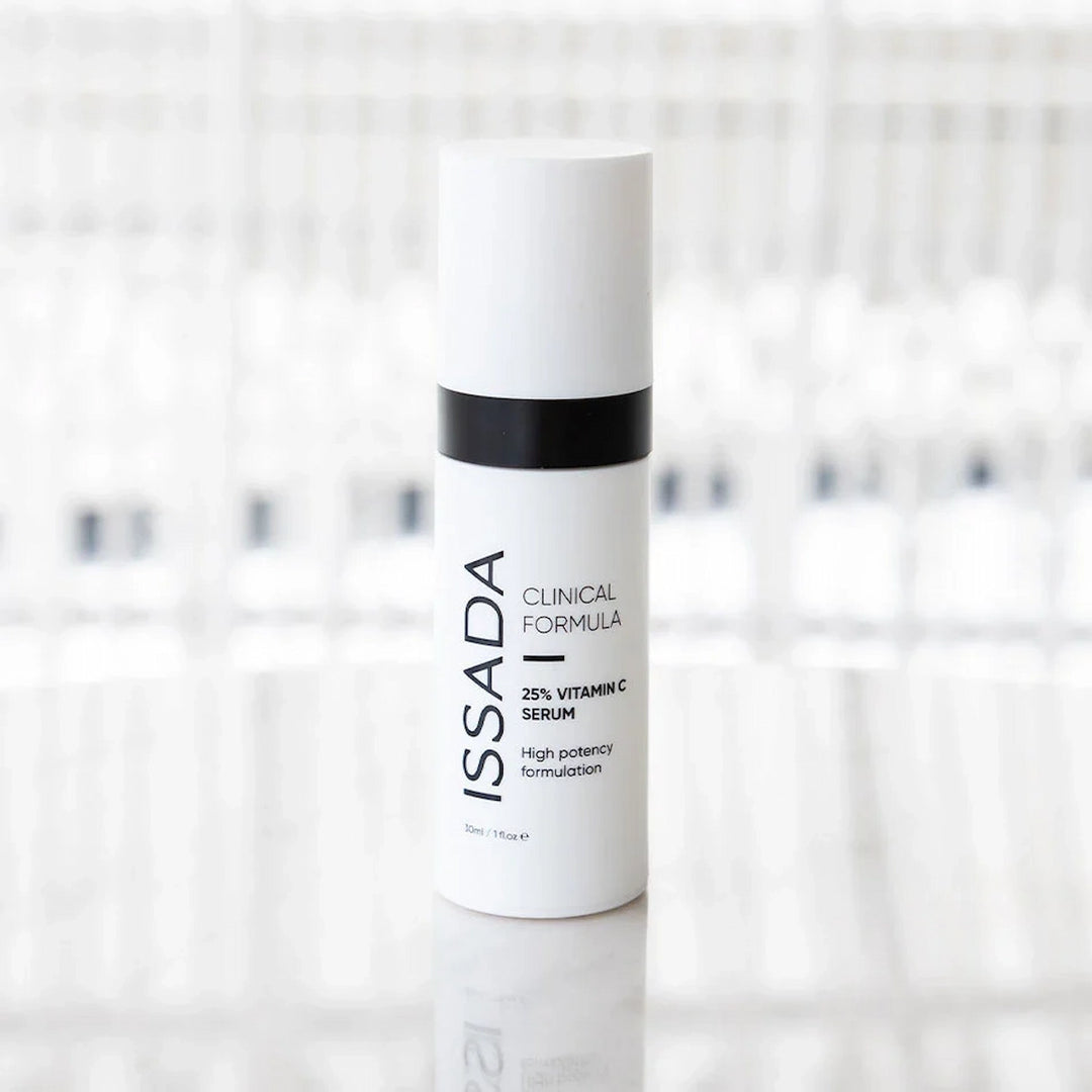 ISSADA 25% Vitamin C Serum standing on reflective surface, high potency formula designed to brighten skin and reduce fine lines.
