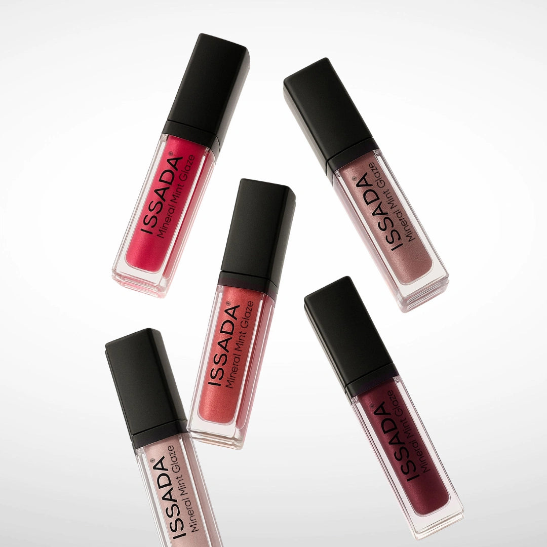 Five ISSADA Mineral Mint Glaze lip gloss tubes in pink, coral, nude and berry shades arranged on a white background.